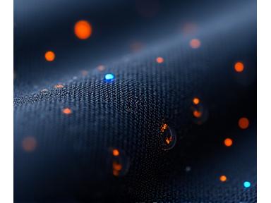 Un gros plan sur un segment de tissu intelligent avec des micro-LEDs discrètement intégrées et des fils conducteurs visibles, illuminant doucement un motif abstrait, sur un fond sombre.